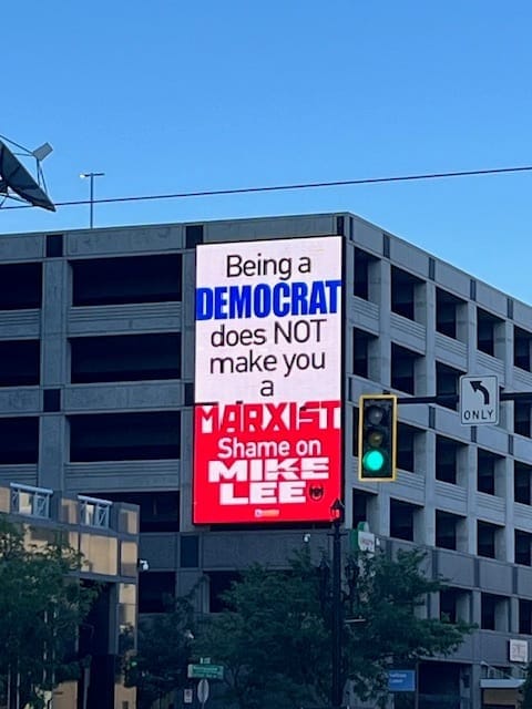 A light up sign that says Being a Democrat does not make you a Marxist, shame on Mike Lee.